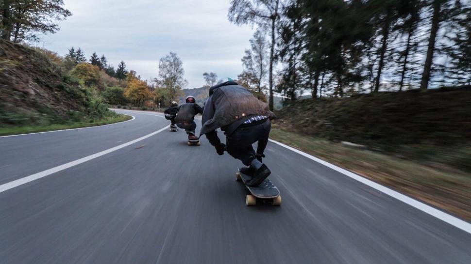 Free Image of Group of People Riding Skateboards Down Road 