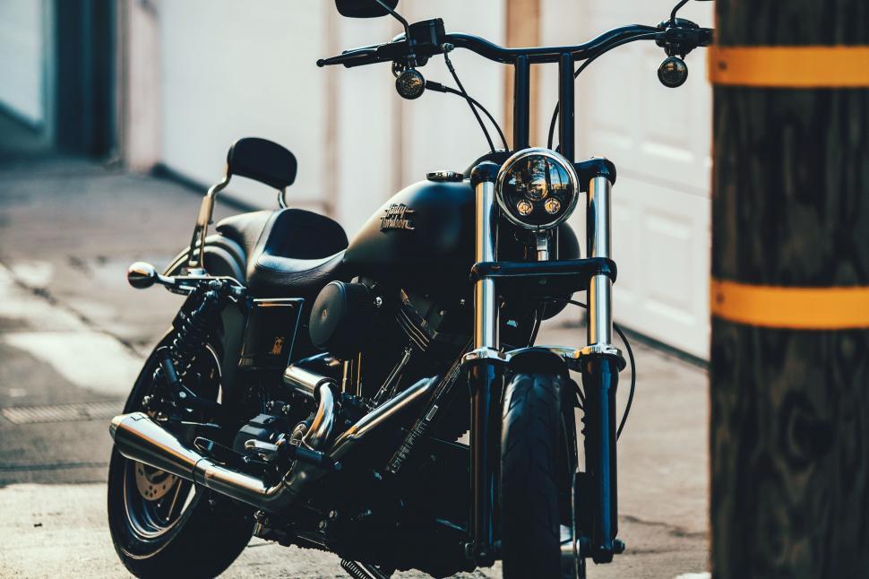 Free Image of Black Motorcycle Parked Next to Pole 