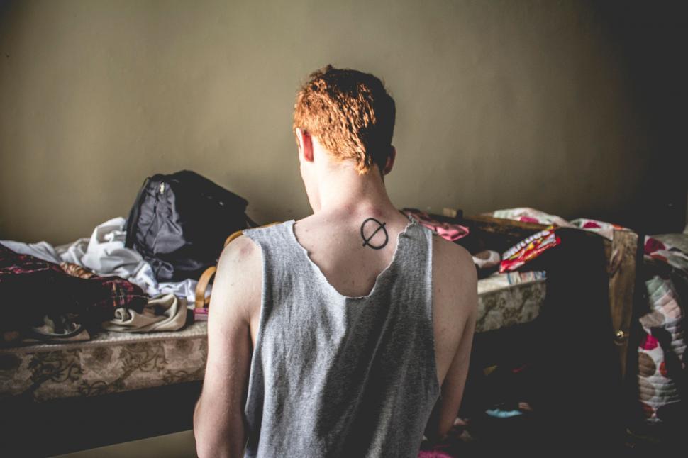 Free Image of Person With Neck Tattoo Standing in Room 