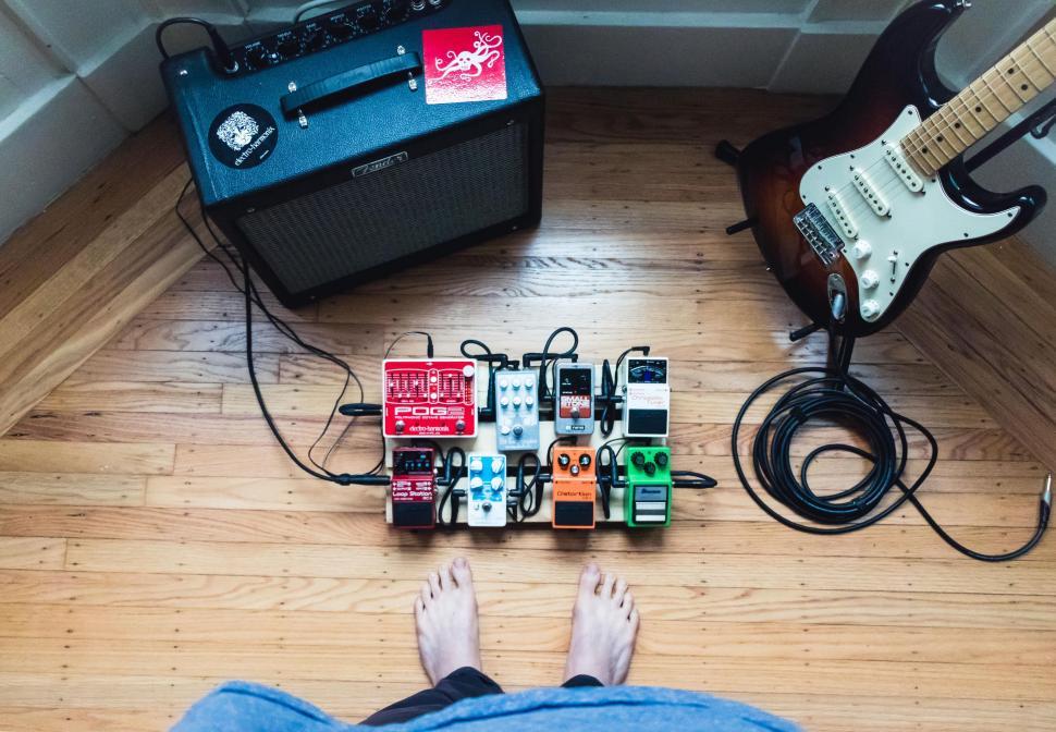 Free Image of Person Laying Next to Guitar and Amp 