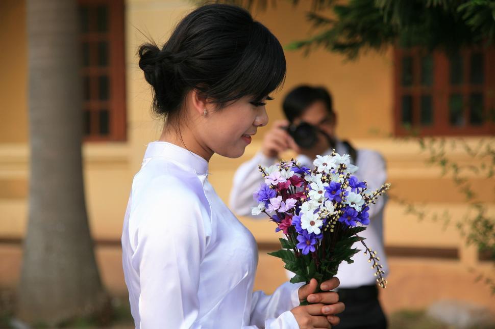 Free Image of Woman Holding Bouquet of Flowers in Front of Man 