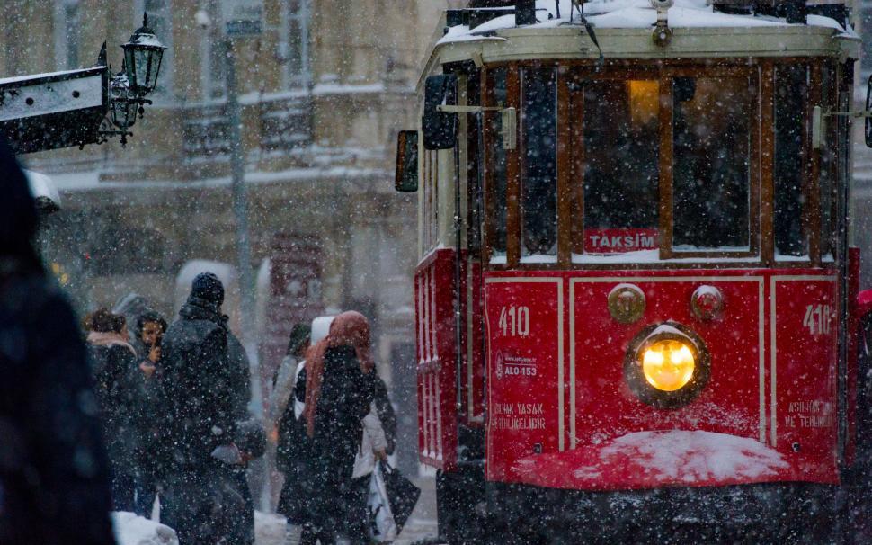 Free Image of Red Trolly Car Traveling Down Snow Covered Street 
