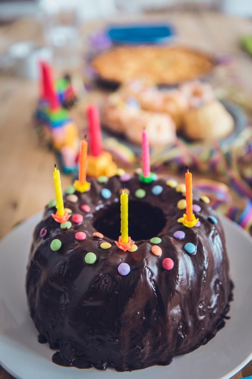 Free Image of Chocolate Bundt Cake With Lit Candles on a Plate 