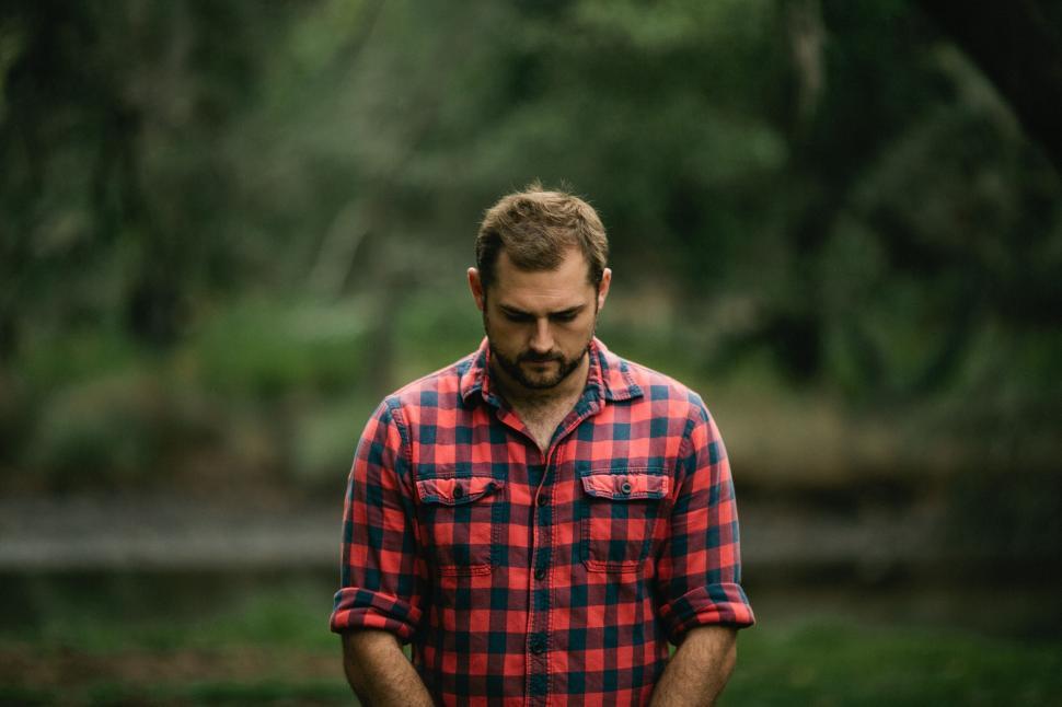 Free Image of Man in Red and Black Plaid Shirt Holding Frisbee 