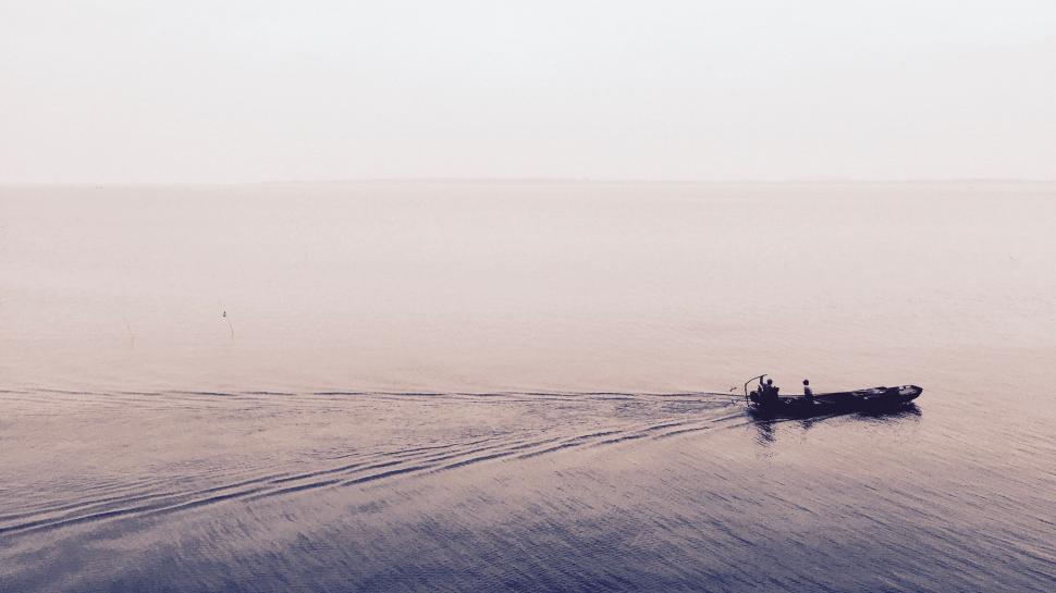 Free Image of Small Boat Crossing Vast Water 