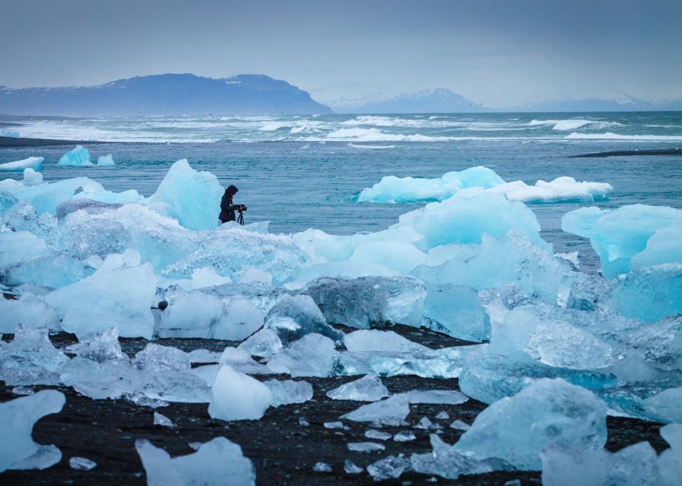 Free Image of Man Standing on Top of Iceberg by Ocean 