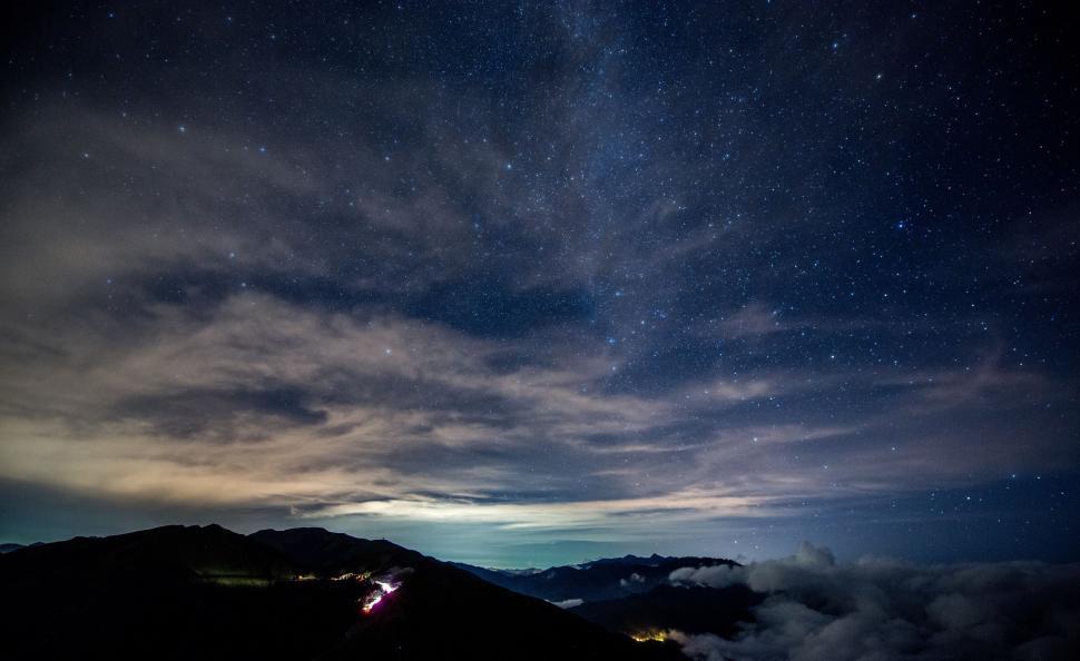 Free Image of Night Sky With Stars and Clouds Above a Mountain 
