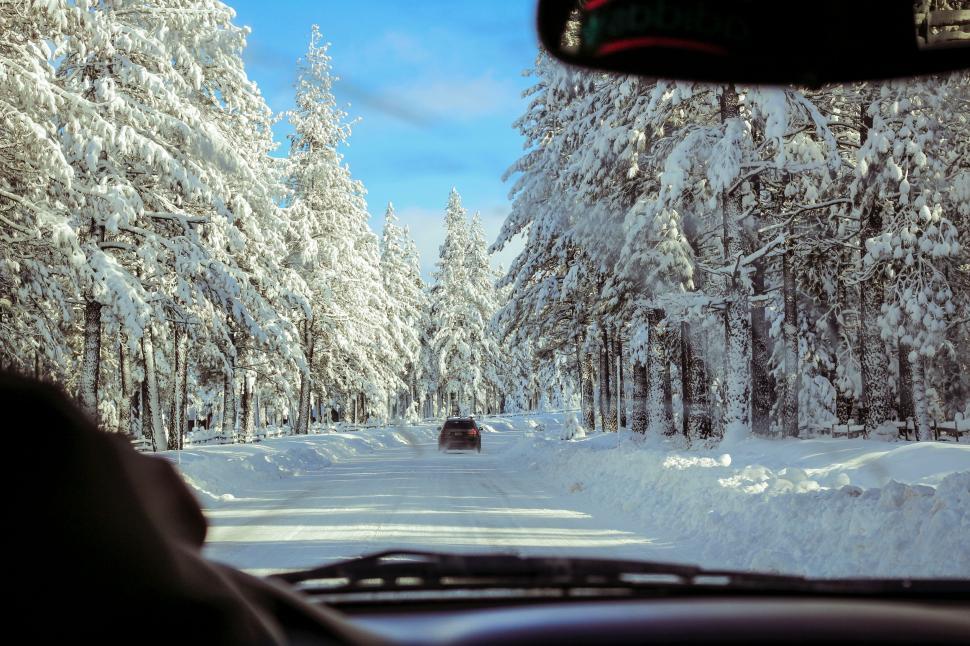 Free Image of Car Driving Down Snow Covered Road 