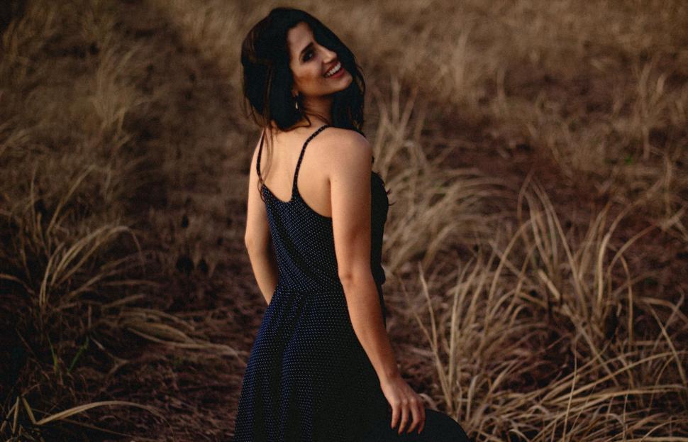 Free Image of Woman in Black Dress Standing in Field 