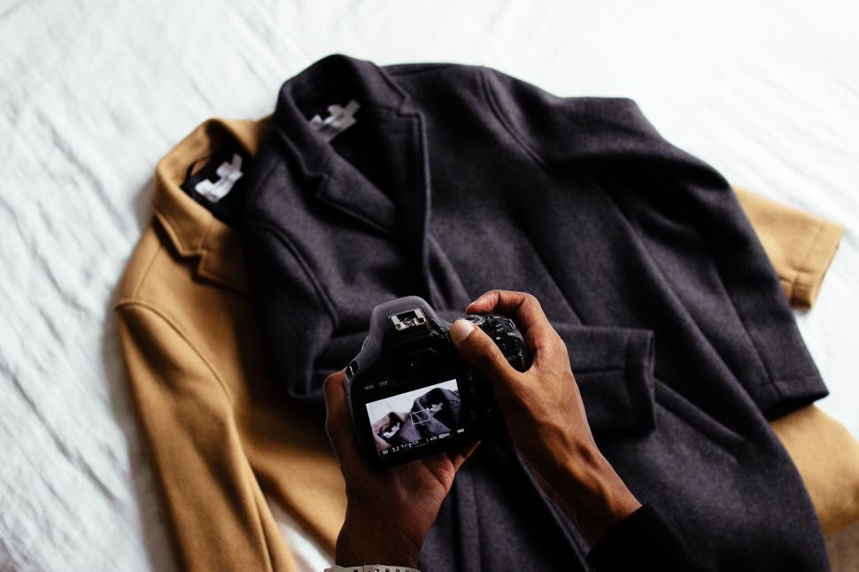 Free Image of Person Holding Camera Next to Jacket 