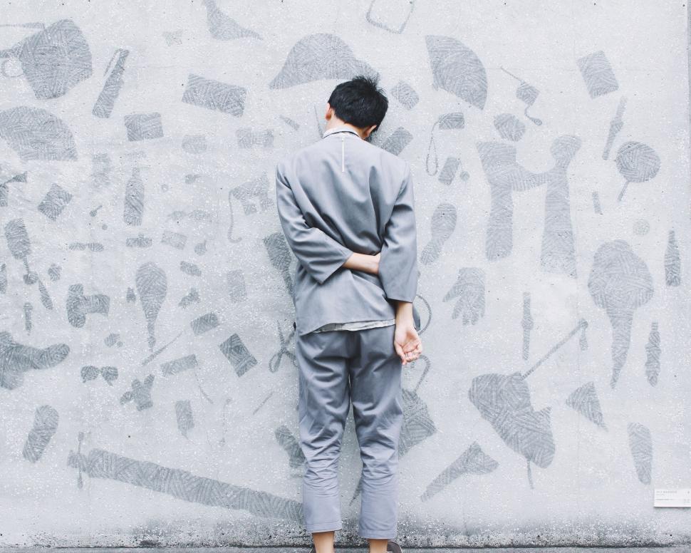Free Image of Man Standing in Front of Graffiti-Covered Wall 