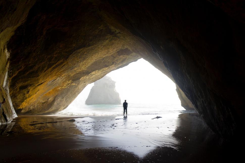 Free Image of Person Standing in the Center of a Cave 
