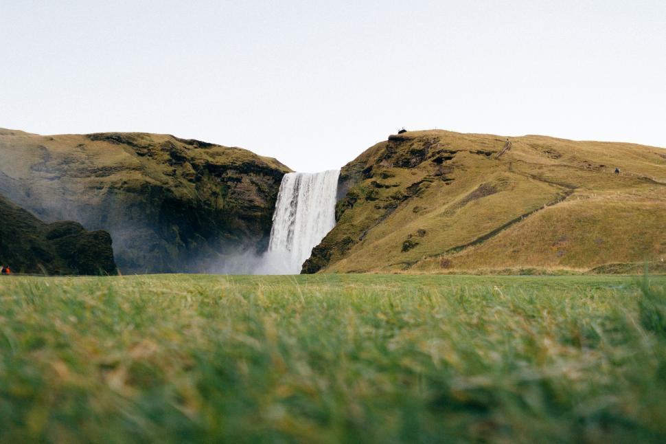Free Image of Grassland With Waterfall in Background 