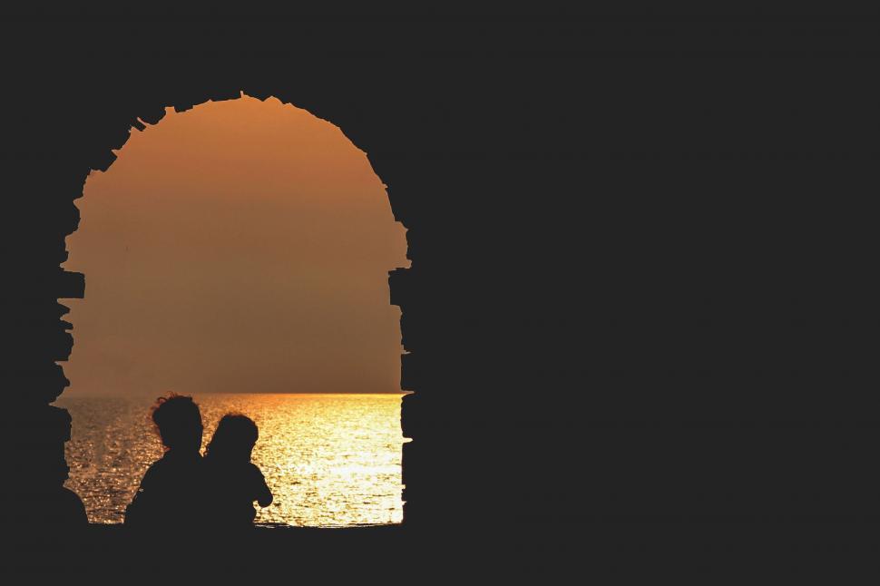 Free Image of Couple Standing Near Body of Water 