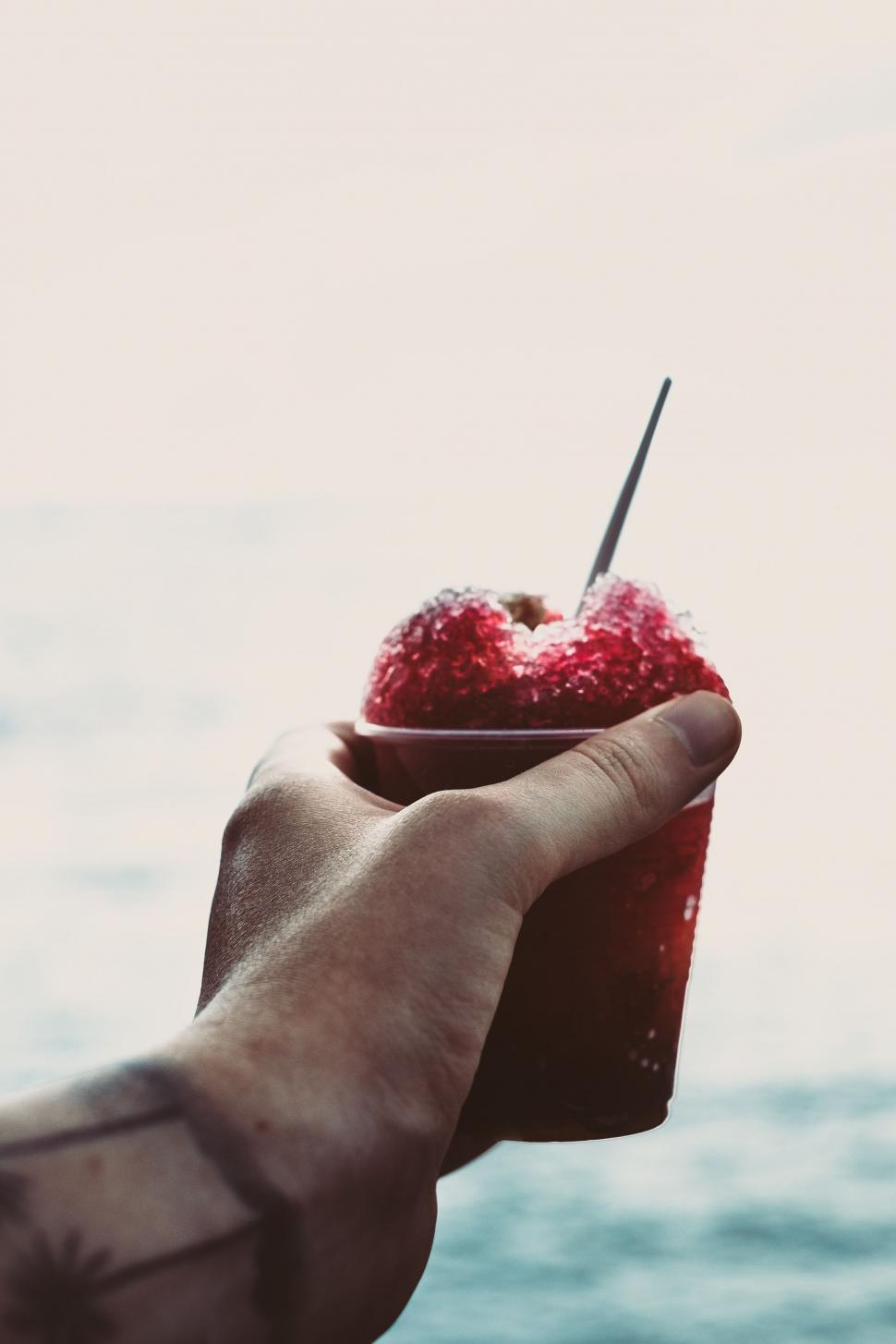 Free Image of Hand Holding Cup With Strawberries 