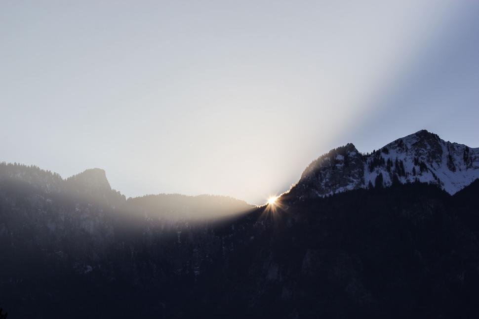 Free Image of Mountain Peak With Sunlight Breaking Through Clouds 