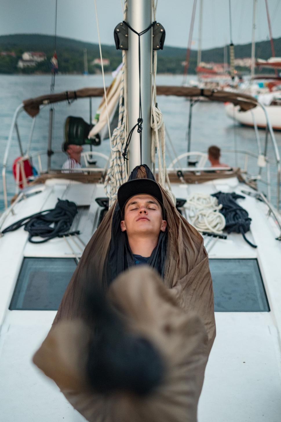Free Image of Man Sleeping on Sailboat on Water 