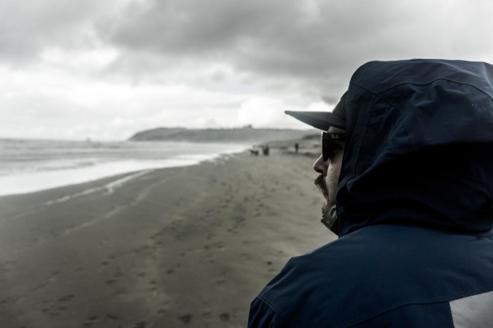 Free Image of Man in Black Jacket and Hat on Beach 