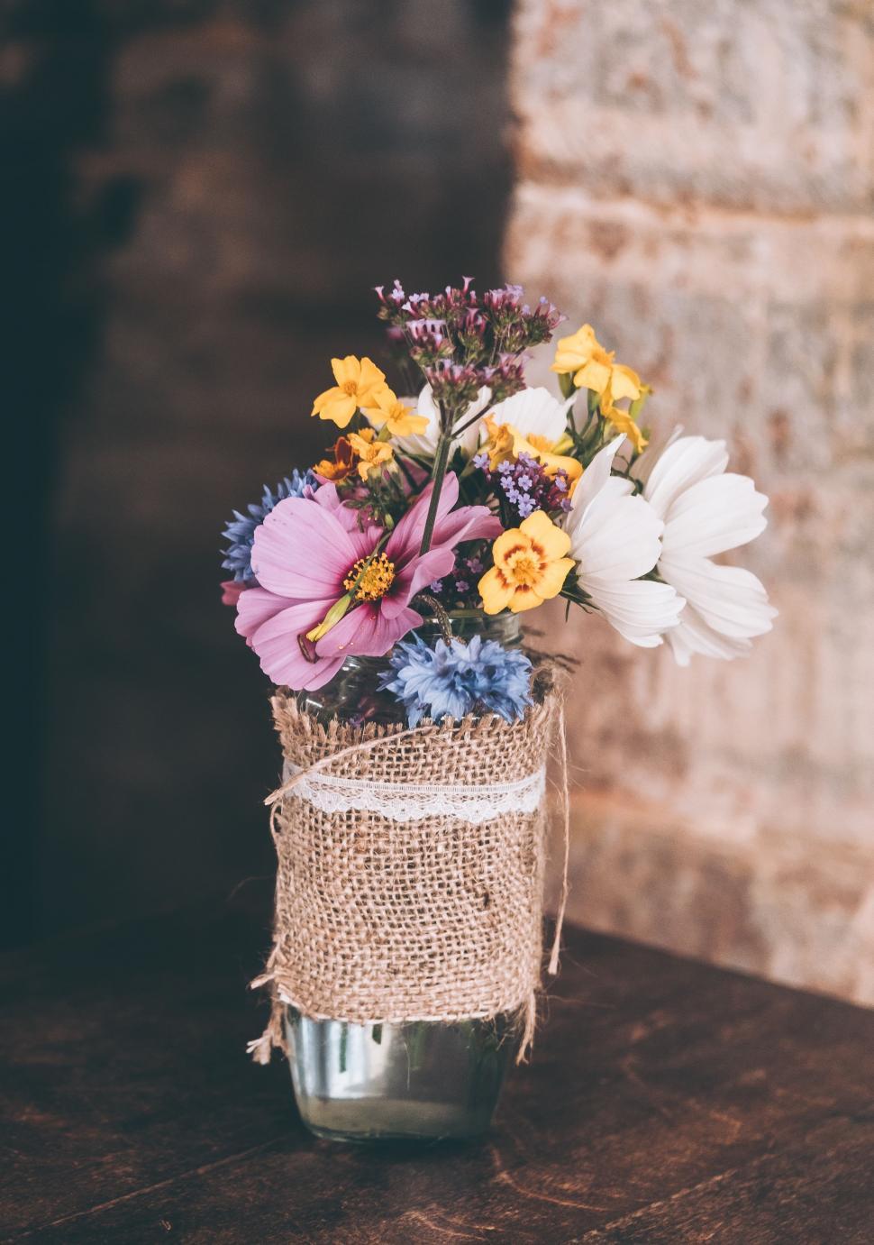Free Image of Vase Filled With Flowers on Wooden Table 