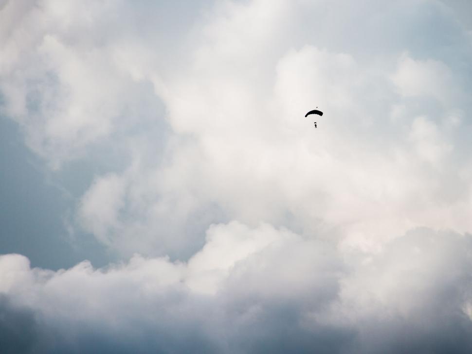 Free Image of Paraglider Flying Through Cloudy Sky 