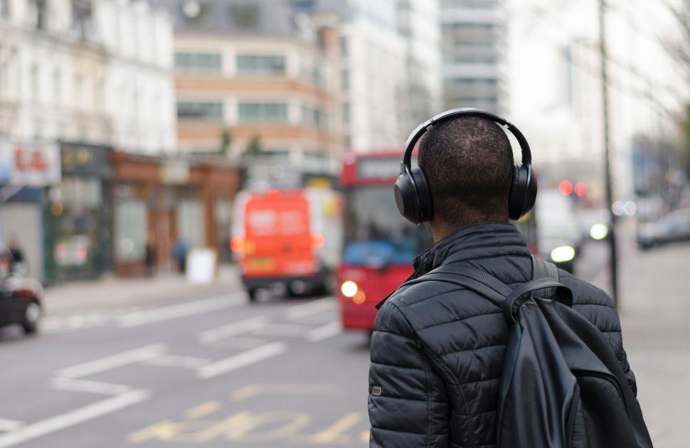 Free Image of Man Wearing Headphones Walking Down a Street 