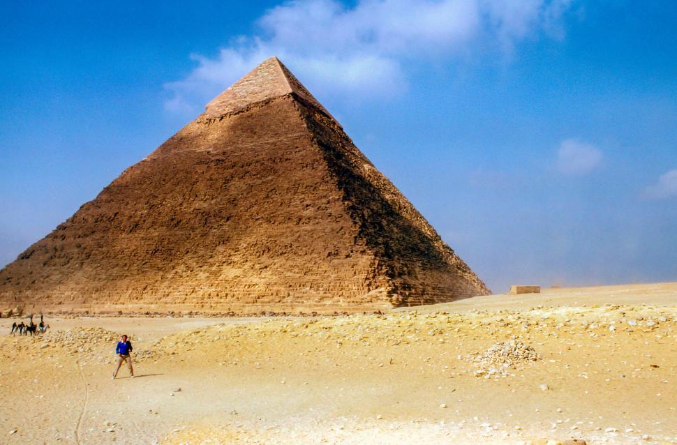 Free Image of Man Standing in Front of a Very Tall Pyramid 