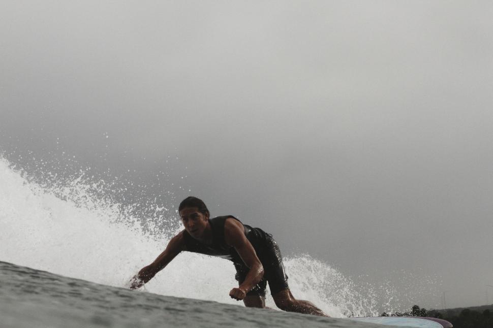 Free Image of Man Riding a Wave on a Surfboard 