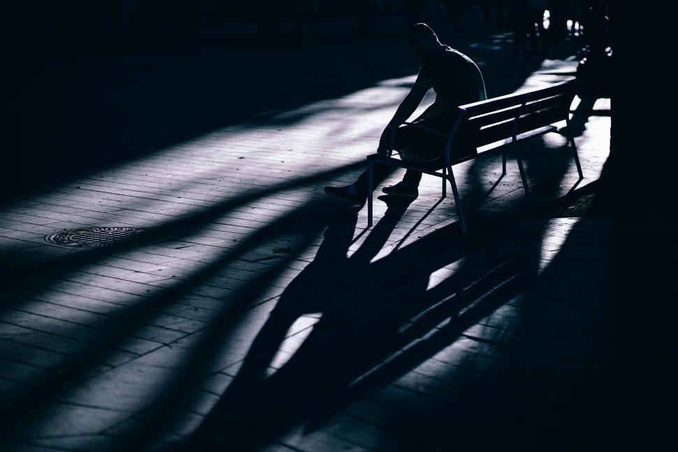 Free Image of Person Sitting on Bench in the Dark 