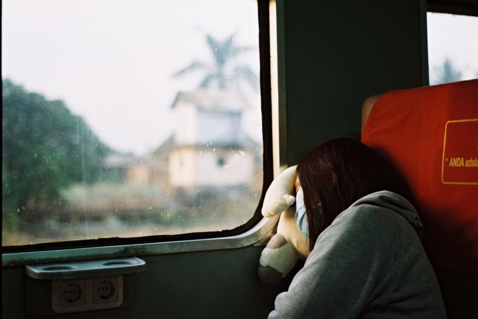 Free Image of Woman Sitting on Train Looking Out Window 