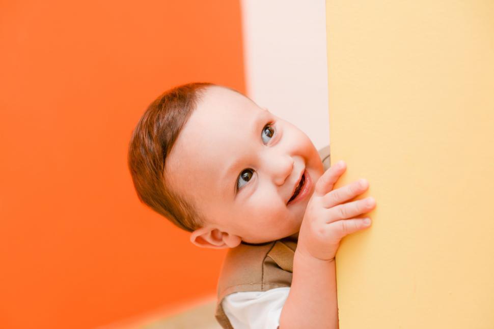 Free Image of Little Boy Leaning Against Wall and Smiling 