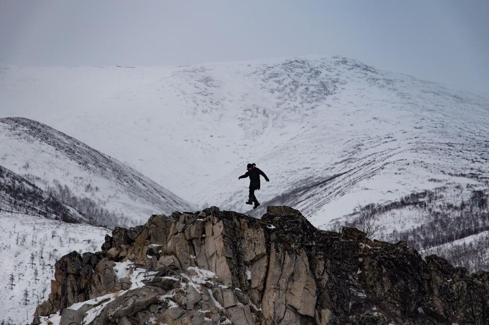 Free Image of Man Standing on Top of Snow Covered Mountain 