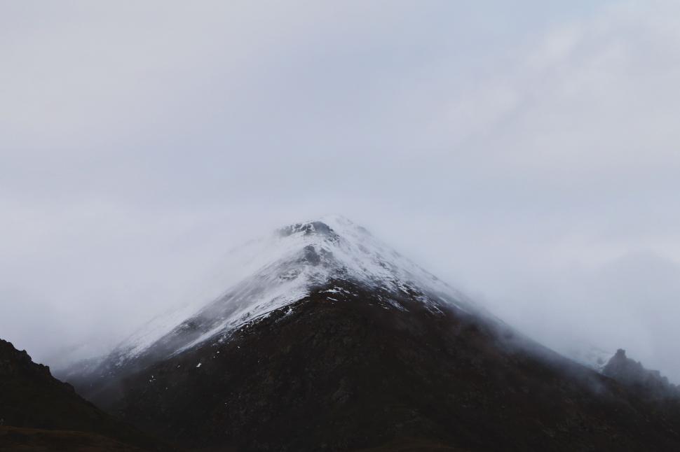 Free Image of Snow-Covered Mountain on Cloudy Day 