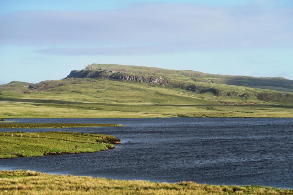 Free Image of A Large Body of Water Surrounded by Green Hills 