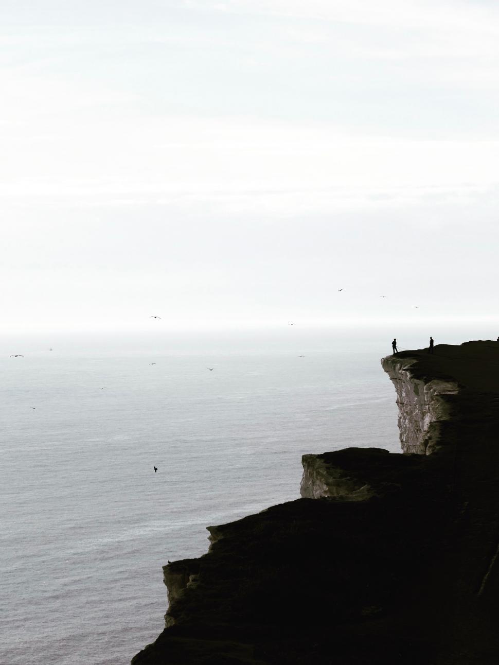 Free Image of Person Standing on Cliff Overlooking Ocean 