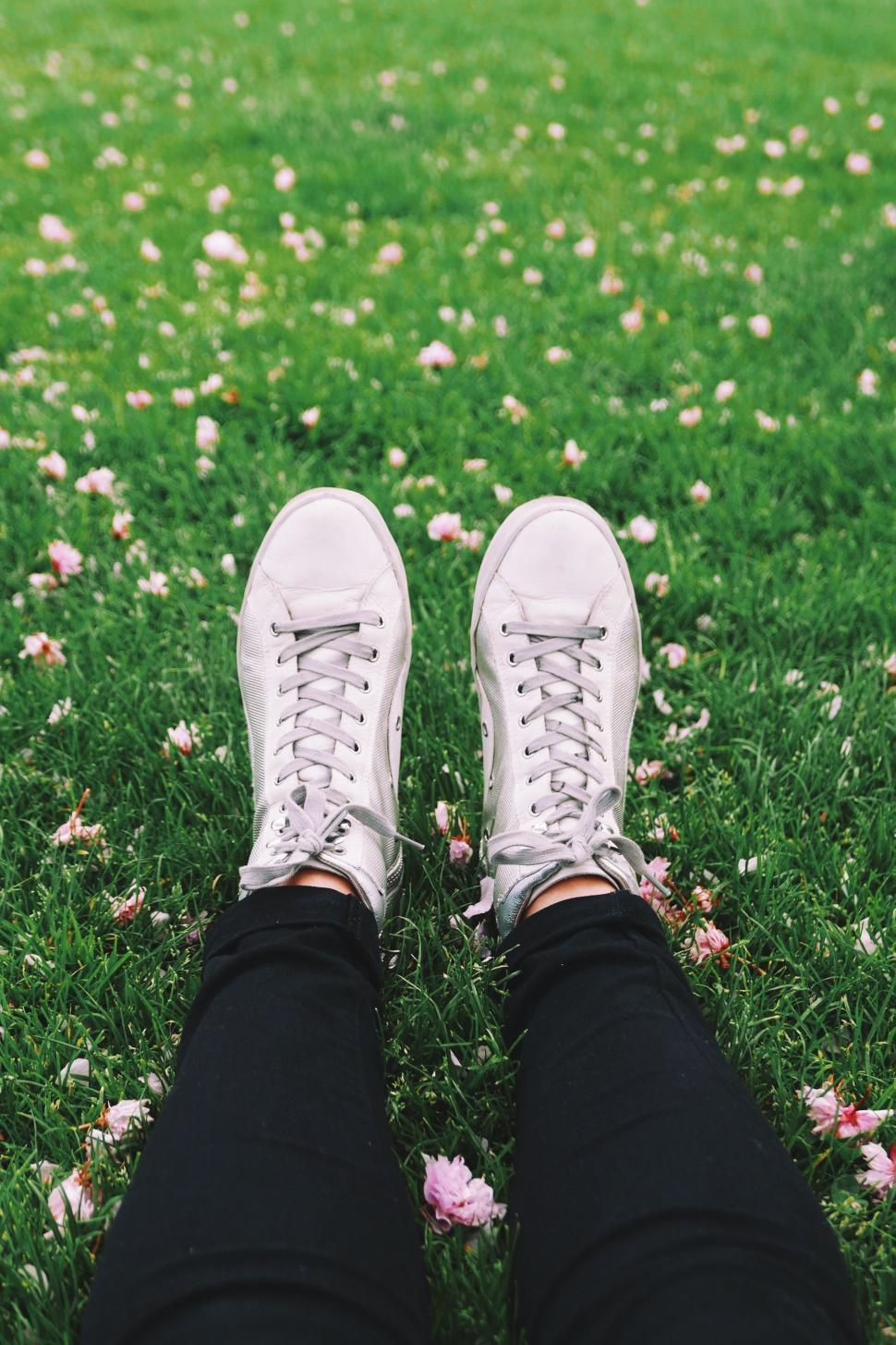 Free Image of Person in White Sneakers Standing in Grass 