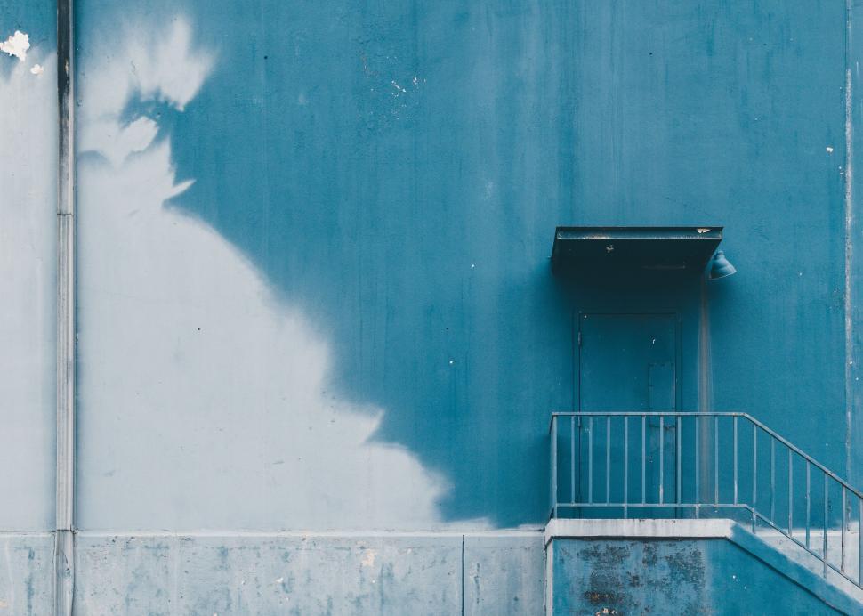 Free Image of Blue Wall With Metal Hand Rail 