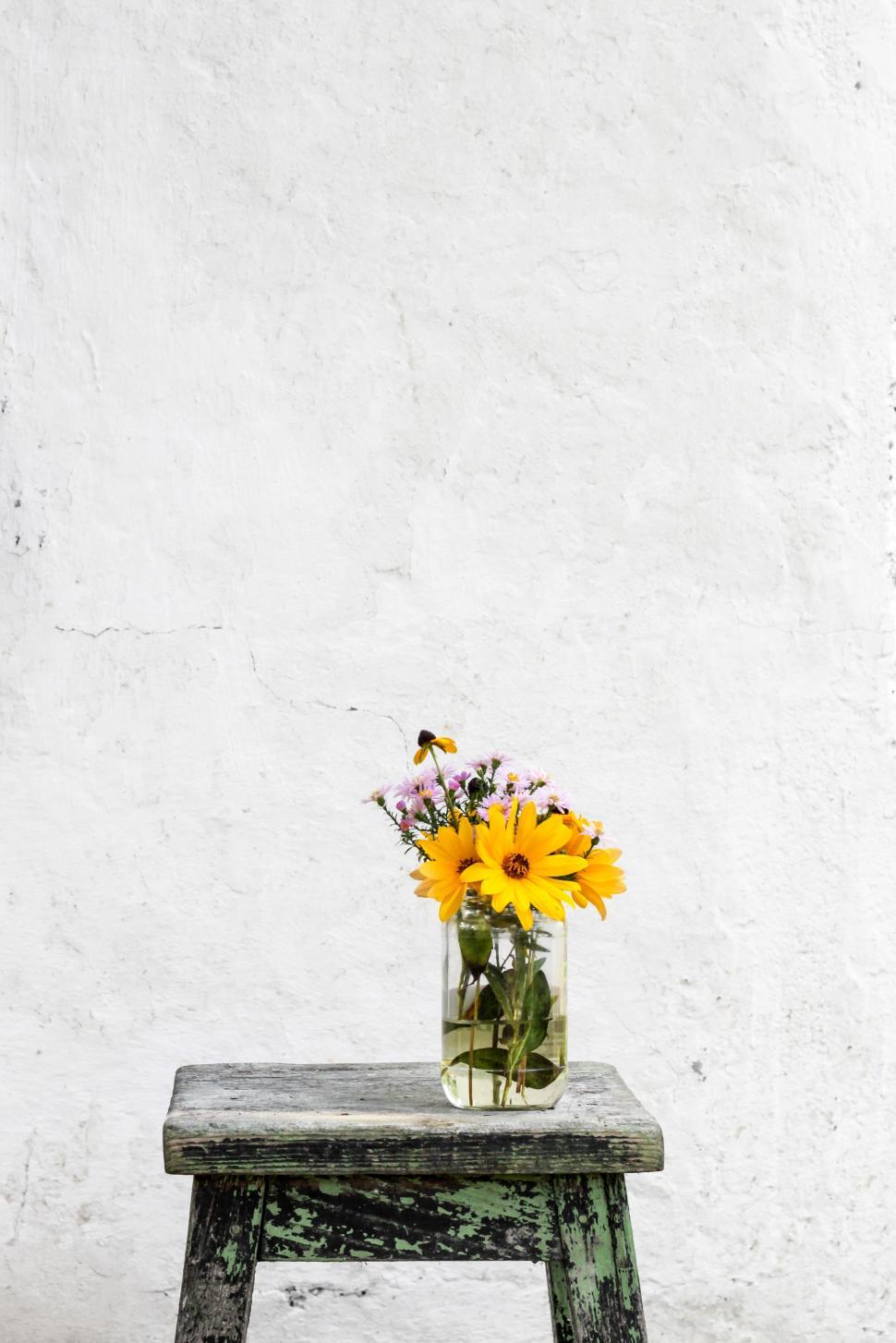 Free Image of Wooden Bench With Vase of Flowers 