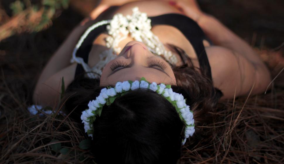 Free Image of Woman Laying on Ground With Headband 