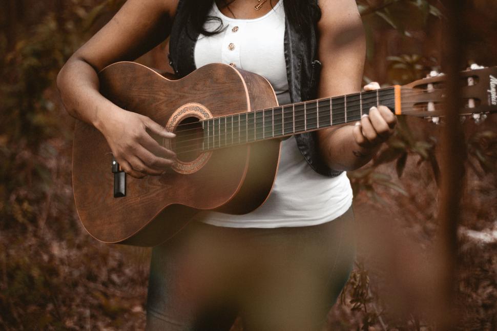 Free Image of Woman Holding Guitar in Forest 