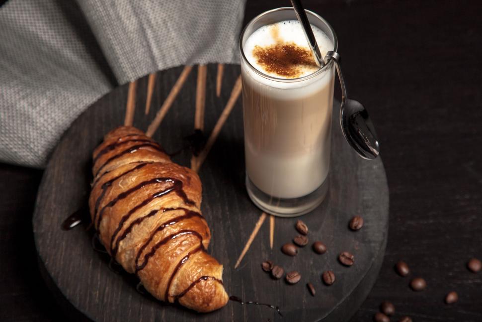 Free Image of A Glass of Coffee and a Croissant on a Plate 