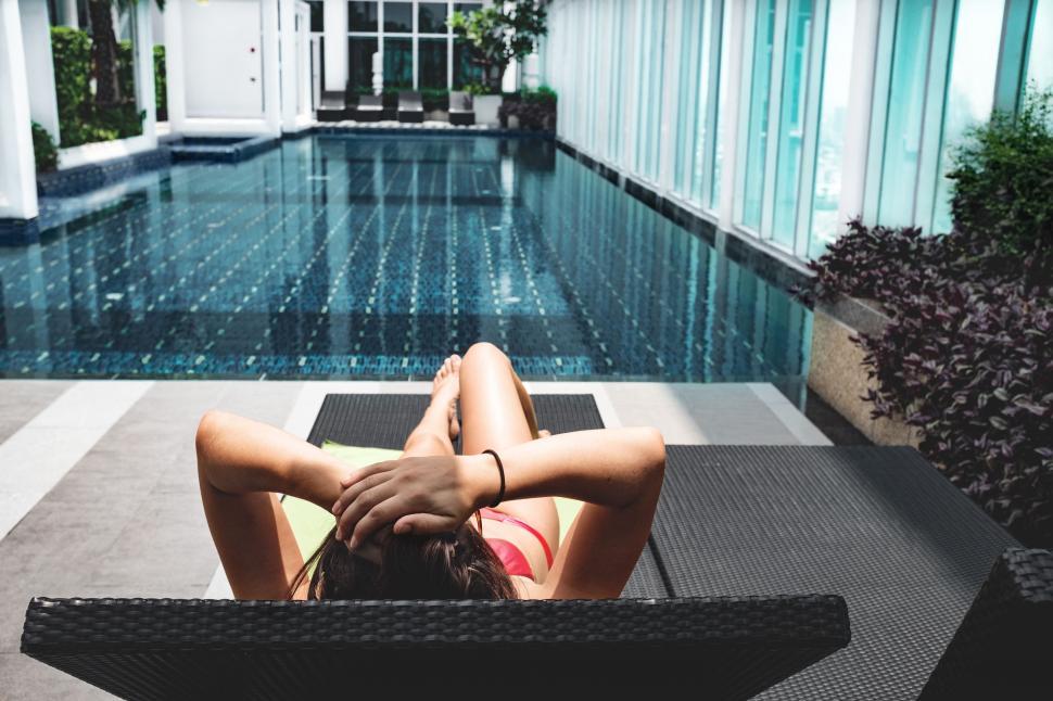 Free Image of Woman Lounging by Swimming Pool 