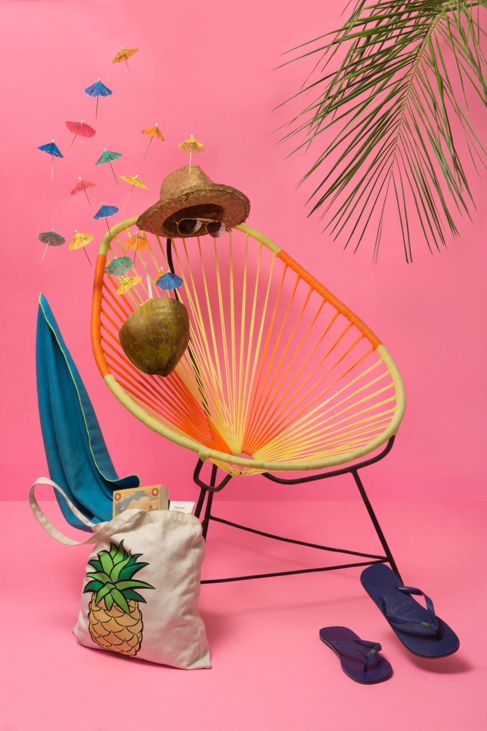Free Image of Pink Background With Chair, Umbrella, Flip Flops, and Pineapple 