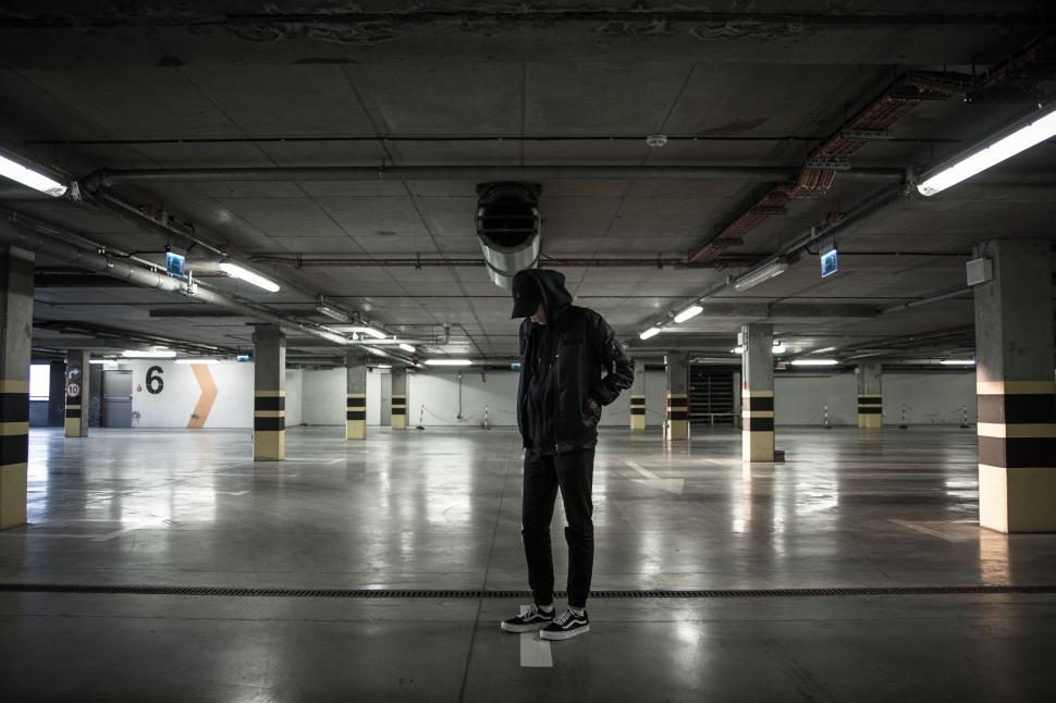 Free Image of Man Standing in Parking Garage With Helmet On 