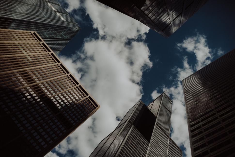Free Image of Group of Tall Buildings With Clouds in the Background 