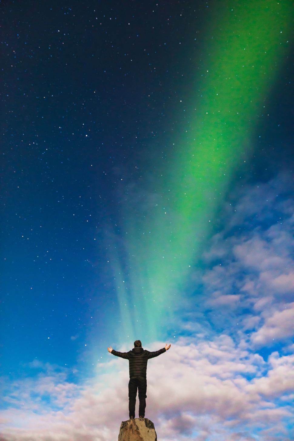 Free Image of Man Standing on Top of Rock Under Green Aurora Bore 