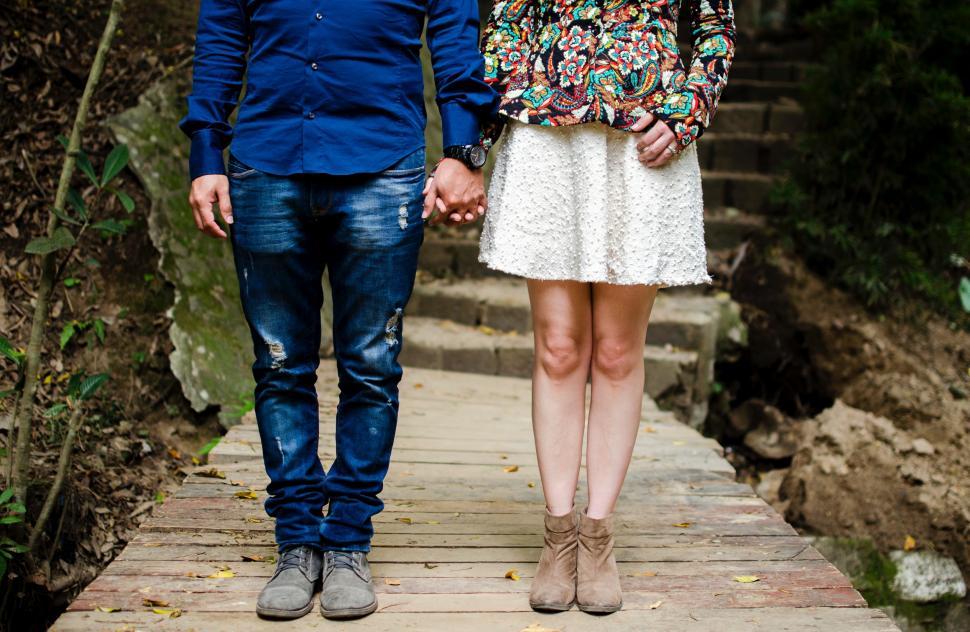 Free Image of Man and Woman Standing on Wooden Walkway 