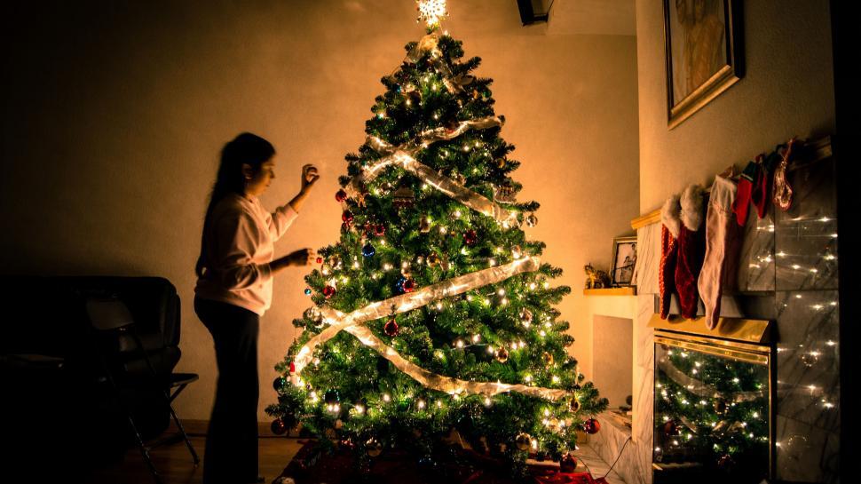 Free Image of Woman Standing in Front of Christmas Tree 