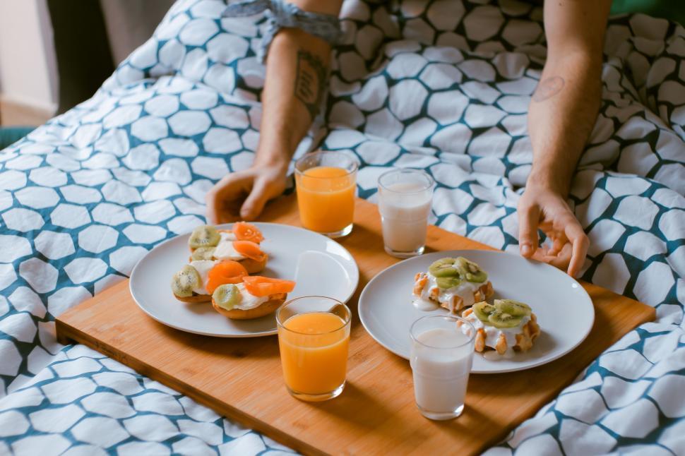 Free Image of Person Sitting on Bed With Tray of Food 