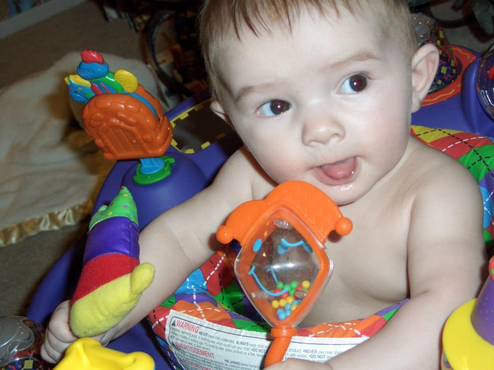 Free Image of Baby Sitting in Chair Holding Toy 