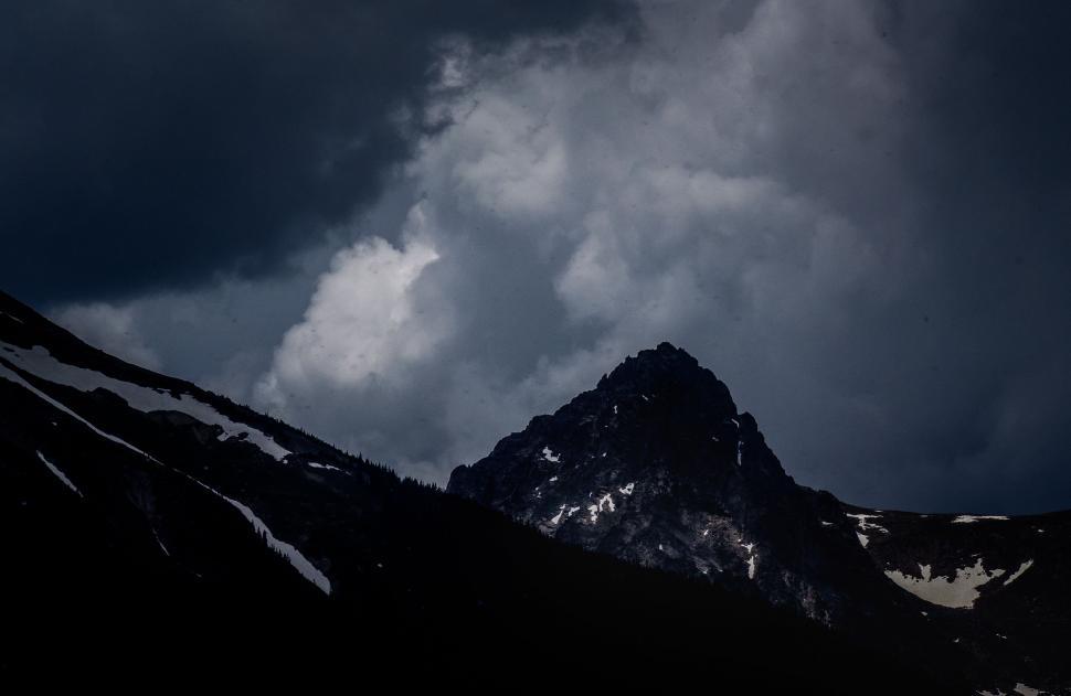 Free Image of Majestic Mountain Peak Under Cloudy Sky 